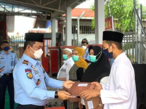 Foto Karutan Kelas IIB Dumai Pance Daniel Panjaitan menyerahkan remisi secara simbolis kepada WBP