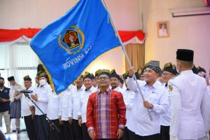 Foto Ketua PWI Provinsi Riau Zulmansyah Sekedang mengibarkan bendera Pataka PWI saat acara pelantikan Pengurus PWI Provinsi Riau