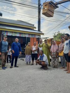 Foto Ketua RT 10 Adong Sinaga bersama warga saat pemasangan lampu jalan di Jalan Sisingamaraja.