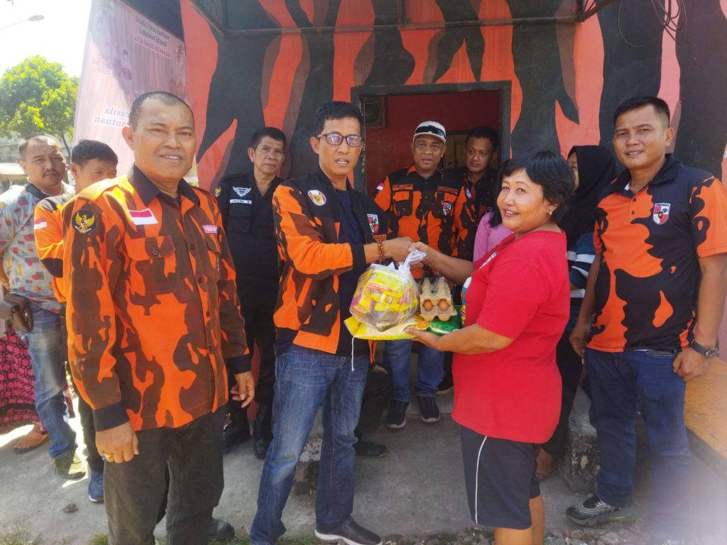 Foto Ketua MPC Pemuda Pancasila Kota Dumai Abdul Kadir, S.H memberikan bantuan secara simbolis kepada warga.