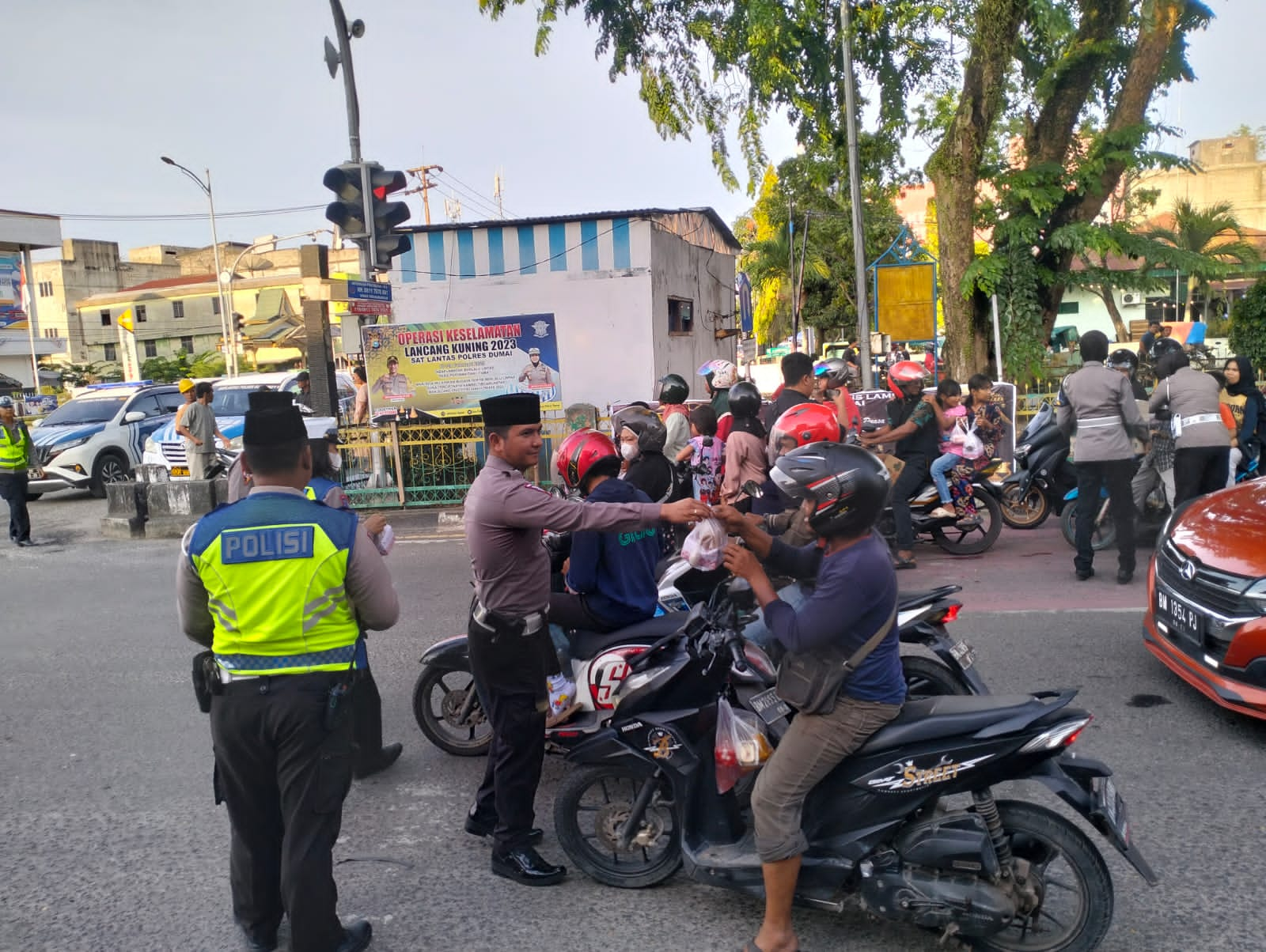 Foto personil Polres Dumai sedang membagi-bagikan takjil kepada pengendara.