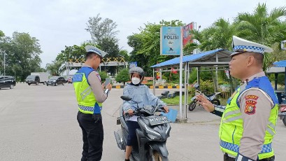 Foto petugas Satlantas Polres Dumai sedang melakukan penilangan menggunakan Electronic Traffic Law Enforcement (ETLE atau tilang elektronik) kepada pengendara kendaraan roda dua.