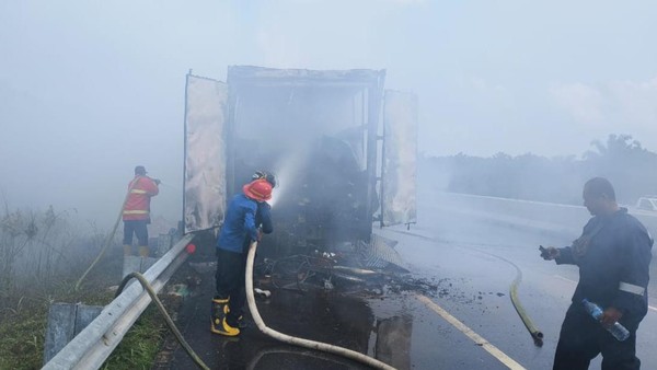 Foto: Petugas memadamkan api di truk tronton yang terbakar di tol Pekanbaru-Dumai. (dok: detiksumut)