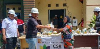 Foto : Mill Manager PT. PKS Christian Daniel P. Sitanggang menyerahkan bantuan CSR perusahaan secara simbolis kepada masyarakat.