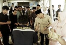 Foto : Bupati Rohil Afrizal Sintong menyambut CJH dari Rohil di Pelabuhan Batam dengan menabur beras kunyit sebagai tanda keberkahan.