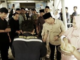 Foto : Bupati Rohil Afrizal Sintong menyambut CJH dari Rohil di Pelabuhan Batam dengan menabur beras kunyit sebagai tanda keberkahan.