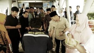 Foto : Bupati Rohil Afrizal Sintong menyambut CJH dari Rohil di Pelabuhan Batam dengan menabur beras kunyit sebagai tanda keberkahan.