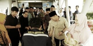 Foto : Bupati Rohil Afrizal Sintong menyambut CJH dari Rohil di Pelabuhan Batam dengan menabur beras kunyit sebagai tanda keberkahan.