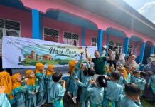 Foto : Salah seorang perwakilan dari Perusahaan Apical bersama siswa siswi yang mendapat bantuan susu.