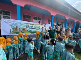 Foto : Salah seorang perwakilan dari Perusahaan Apical bersama siswa siswi yang mendapat bantuan susu.