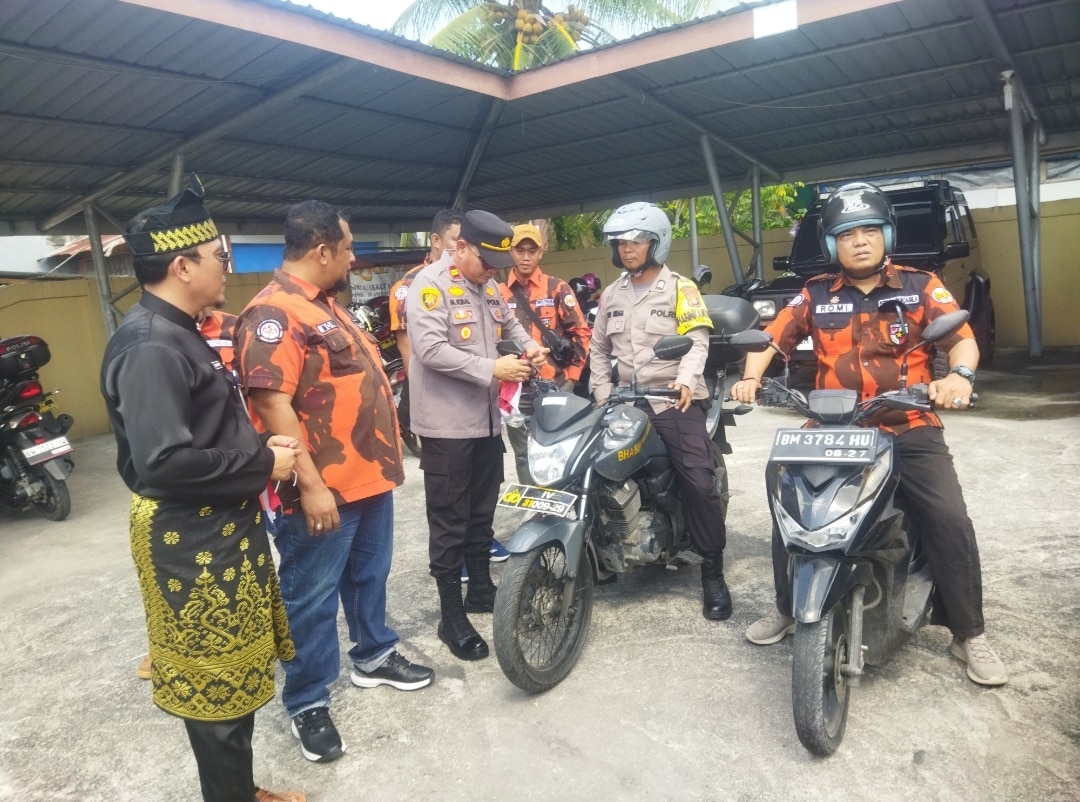 Foto : Kapolsek Dumai Kota IPTU M. Iqbal, S.H., M.H, memasang bendera merah putih secara simbolis.