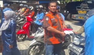 Foto : Ketua PAC Pemuda Pancasila Dumai Kota Asnur Memori memasang bendera merah putih di sepeda motor.